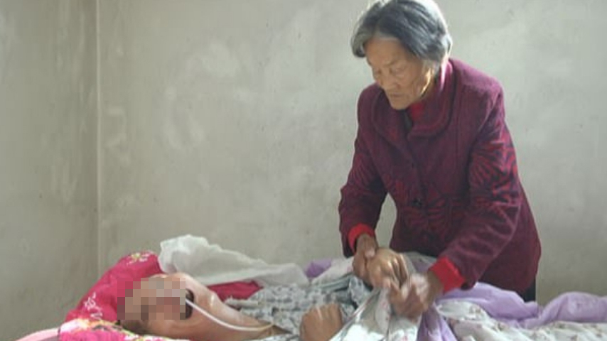 Wei Mingying mentre accudisce il figlio. Credits: Jining News