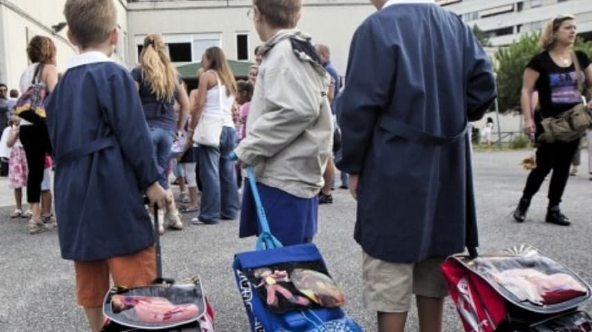 bambini con lo zaino fuori da una scuola