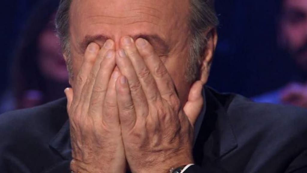 Gerry Scotti mentre trattiene le lacrime nello studio di il milionario