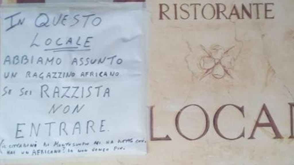 cartello ragazzo colore insulti