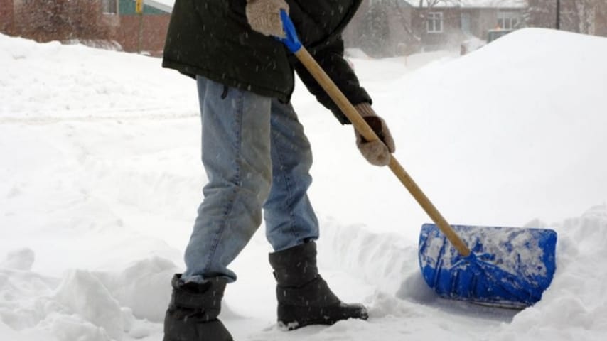 uomo che spala la neve dal viale