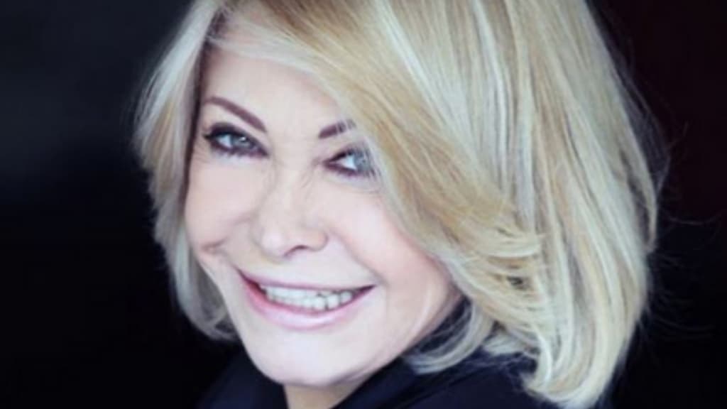 Paola Quattrini sorride. Foto su sfondo nero