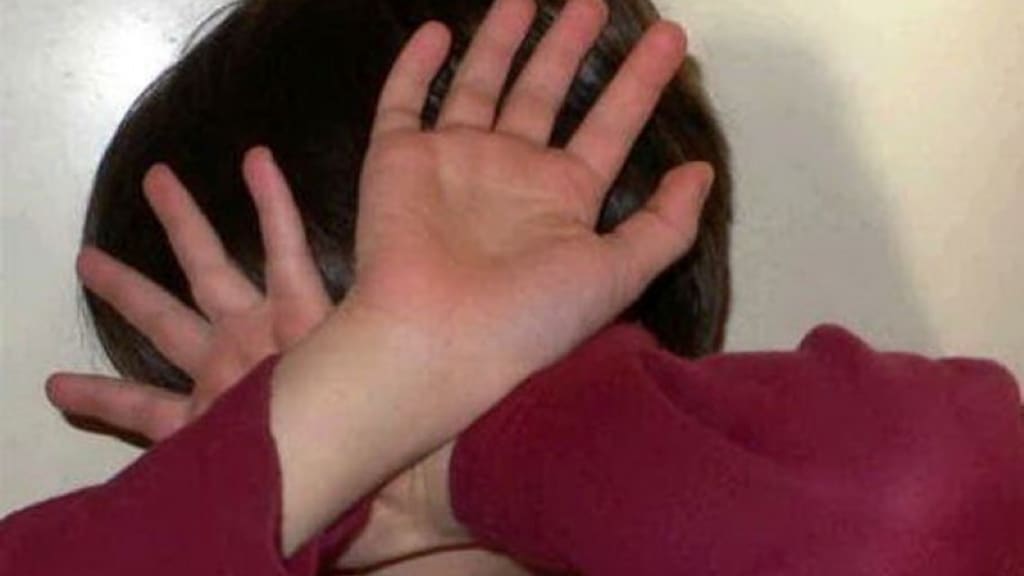 primo piano di un bambino che cerca di difendersi il volto con le mani davanti