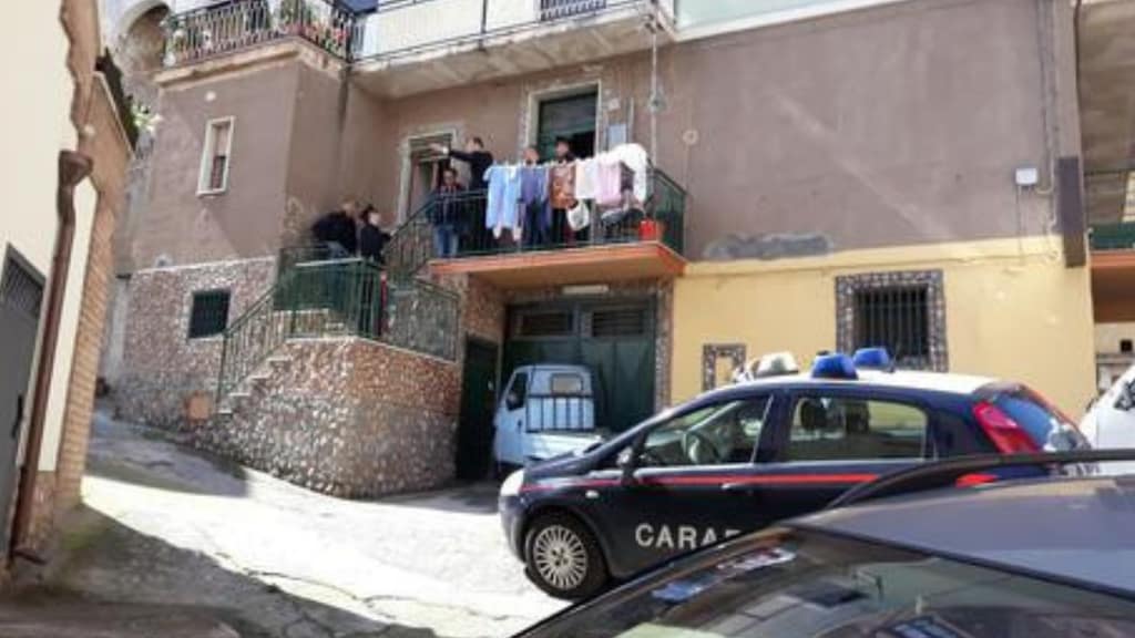 la faccia della casa della vittima con innanzi una volante dei carabinieri