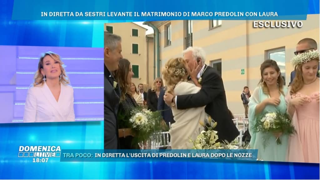 barbara d'urso mentre osserva laura fini e marco predolin vestiti da sposi mentre si baciano