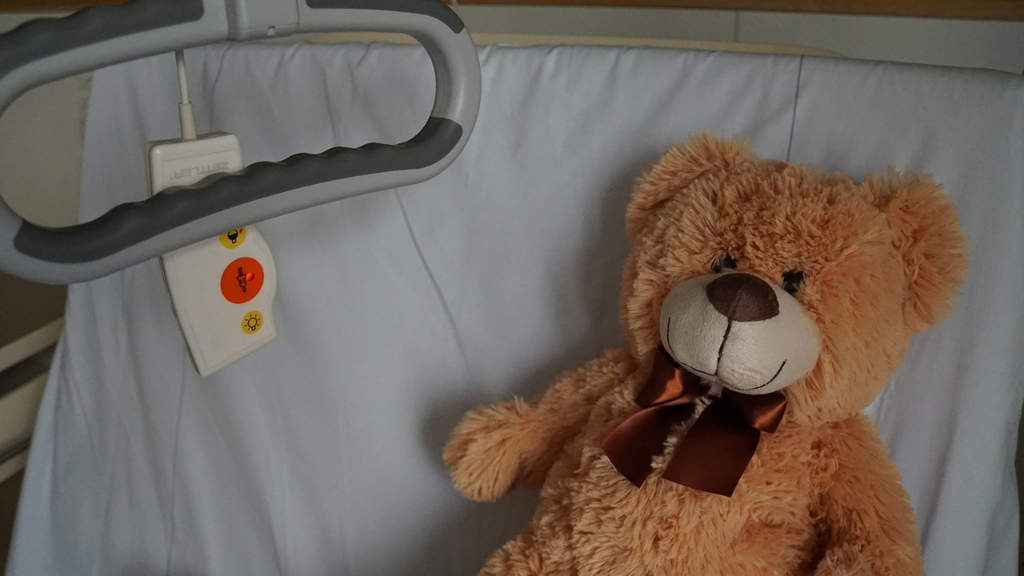 peluche a forma di orso in un letto d'ospedale