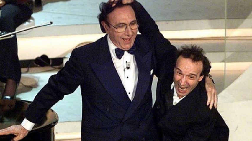 pippo baudo e roberto benigni mentre scherzano sul palco dell'ariston