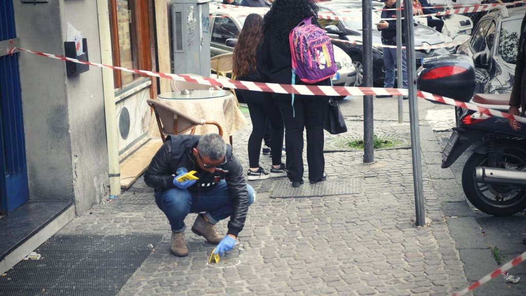 La polizia comincia le indagini dopo la sparatoria raccogliendo prove sulla scena