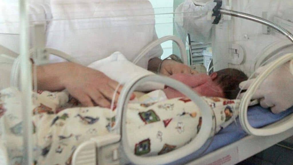bambino sdraitato dentro incubatrice