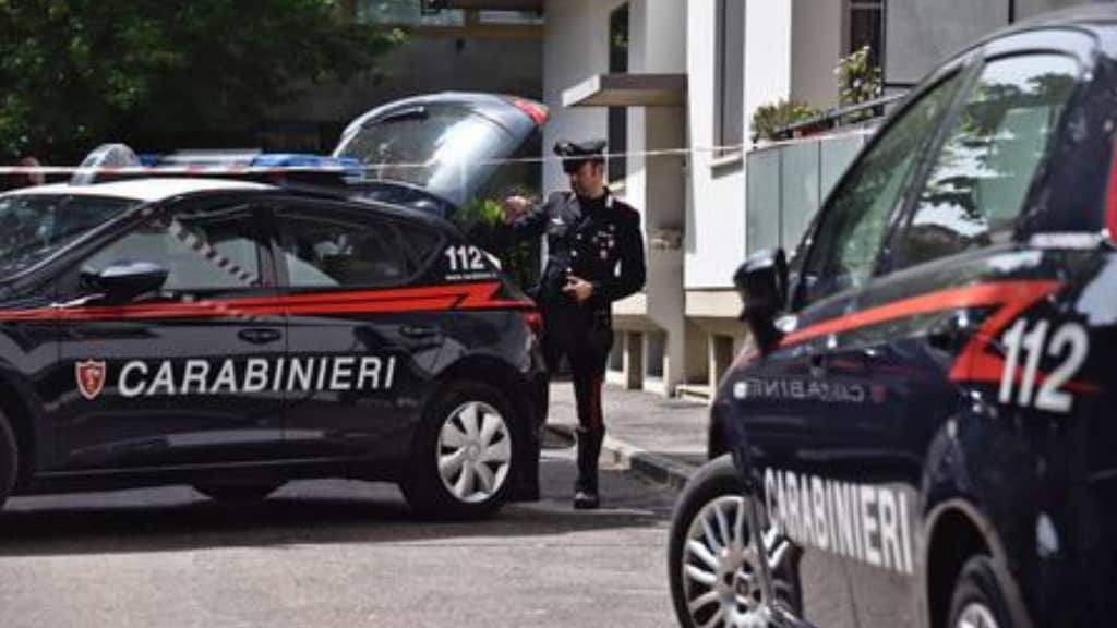 un carabiniere mentre apre il bagagliaio di una volante