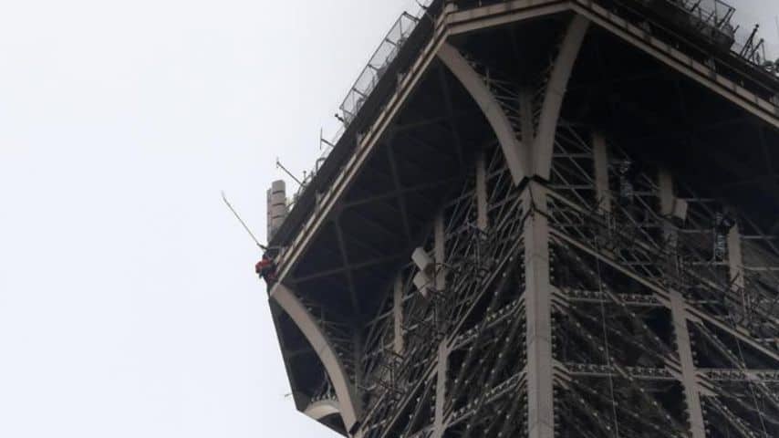 tour eiffel uomo si arrampica