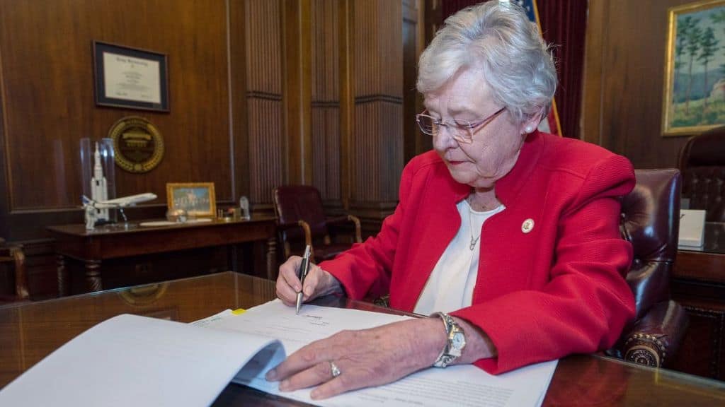 kay ivey mentre firma la legge sull'aborto