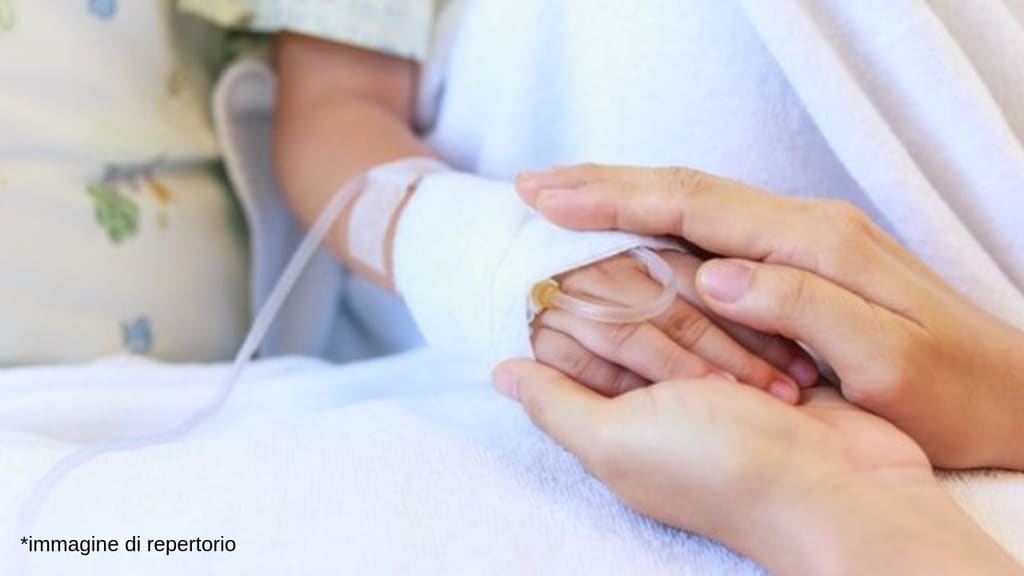 mano di una bimba in ospedale con la flebo