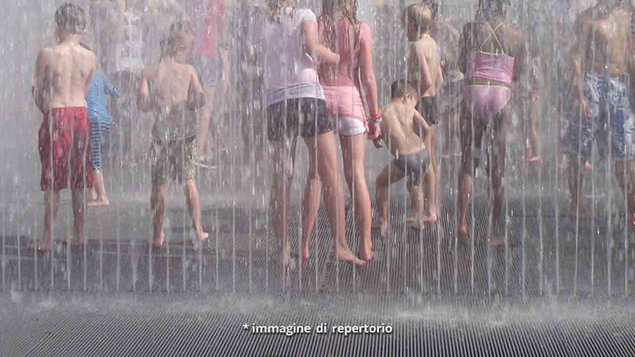 gambe di bambini dietro zampilli d'acqua
