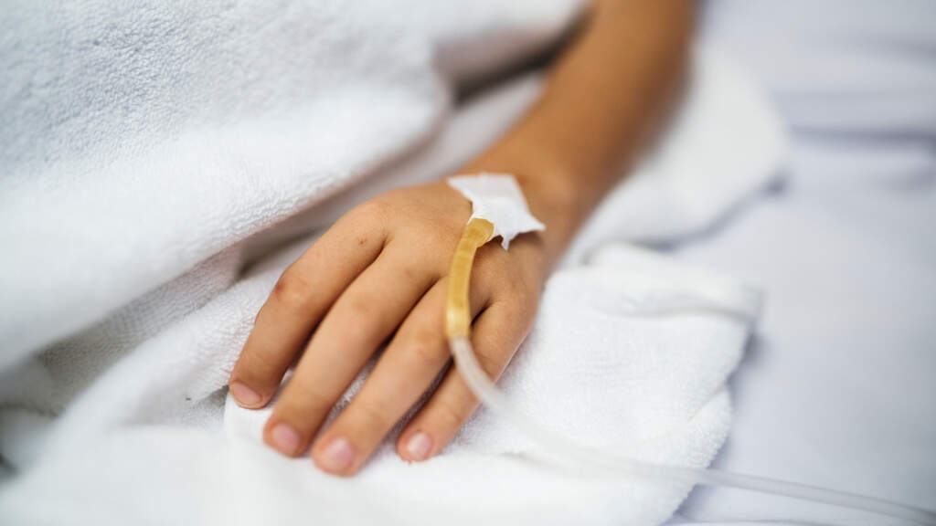 mano in letto di ospedale con flebo