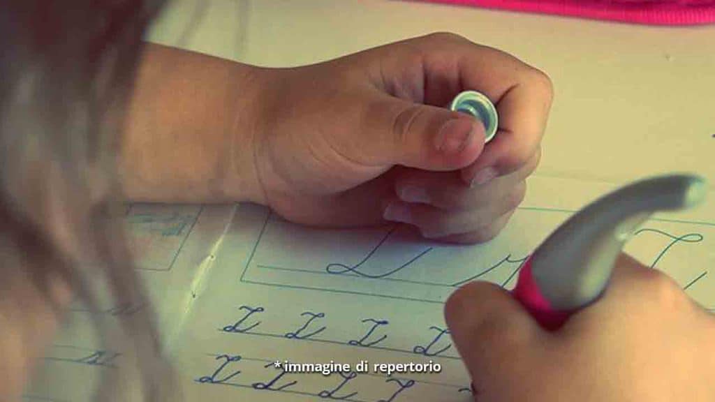 mano di una bimba che scrive