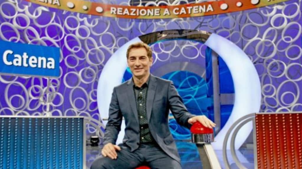 Il conduttore Marco Liorni seduto nello studio di "Reazione a Catena"