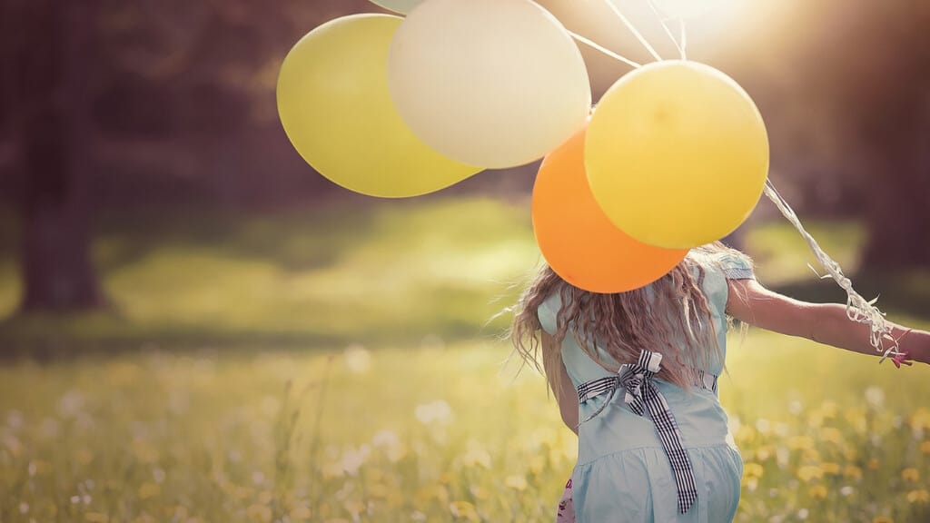 Una ragazza che regge alcuni palloncini