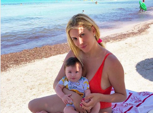 paola caruso al mare sdraiata con in braccio michelino