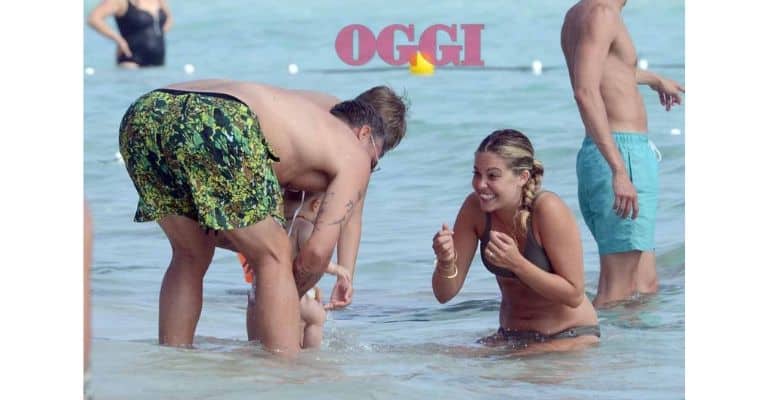 Bobo Vieri tiene in braccio la piccola Stella mentre la mamma, Costanza Caracciolo la attende in acqua