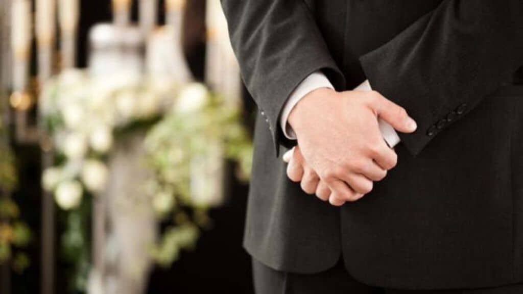 mani congiunte di una persona a lutto