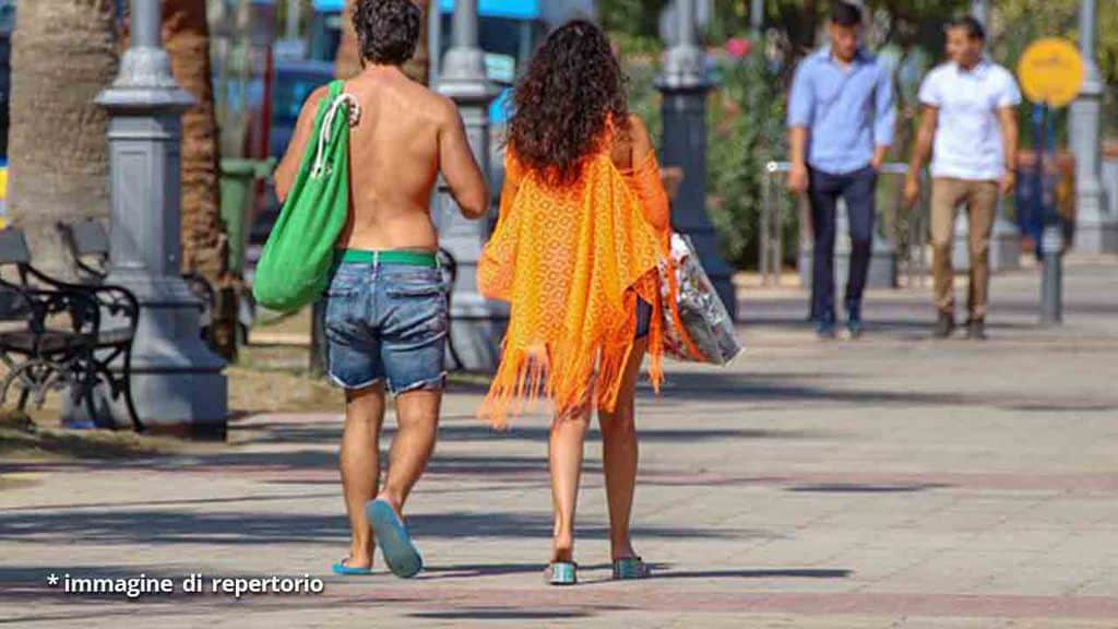 coppia che cammina per strada tra la gente