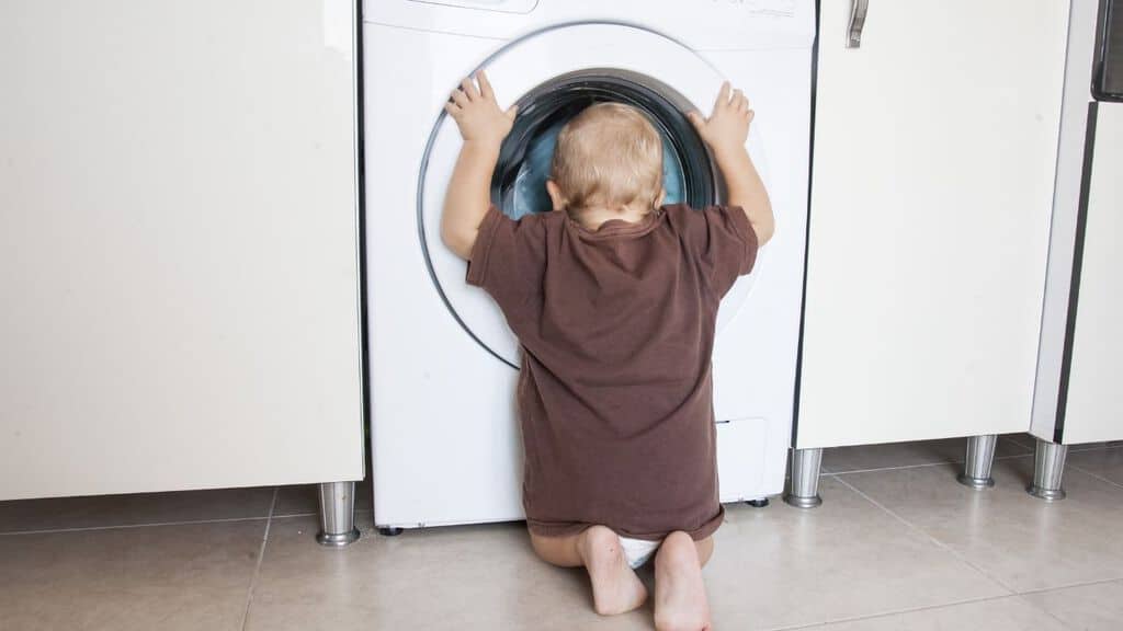 Bambino che guarda nell'oblò della lavatrice