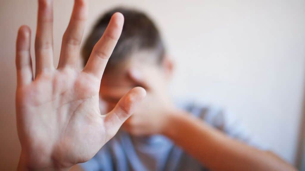 un bambino che si copre il viso