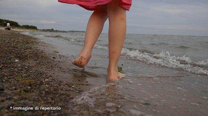 gambe di ragazza in spiaggia