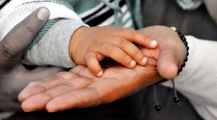 mano di bimbo nella mano di un adulto