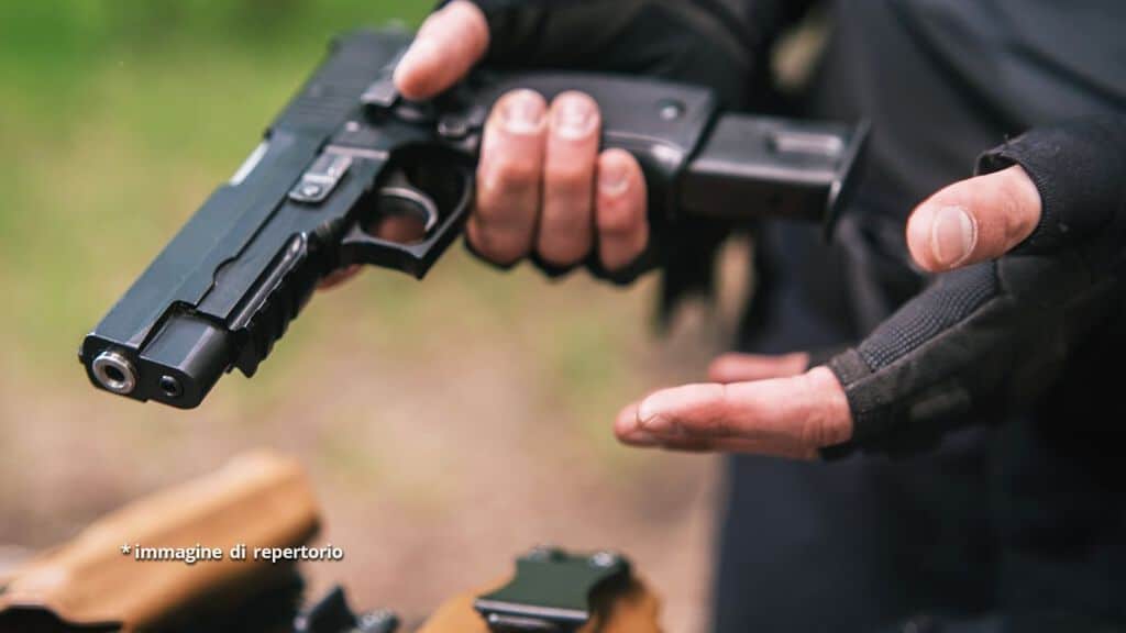 uomo con in mano pistola