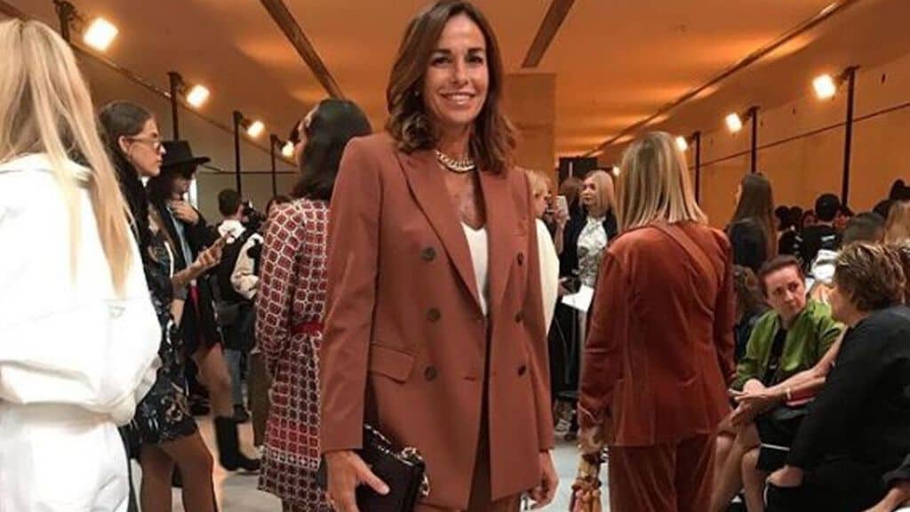 Cristina Parodi in abito marrone sorride alla fotocamera