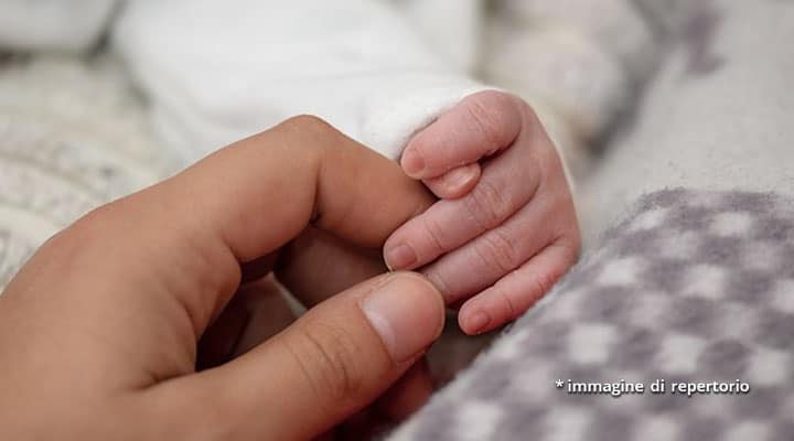 mano di donna e neonato