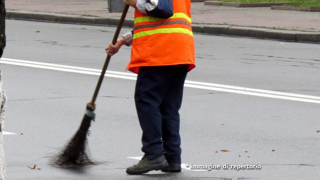 uomo che raccoglie foglie per strada