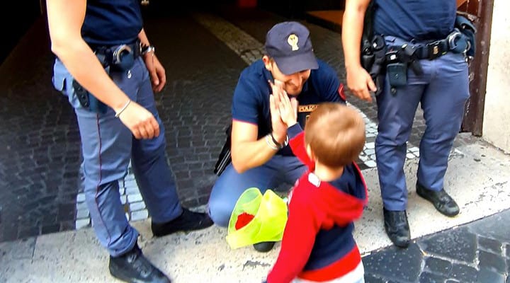 Bimbo consegna fiore ai poliziotti