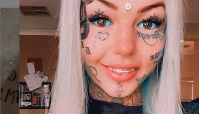 ragazza con occhi tatuati di blu e molti tatuaggi