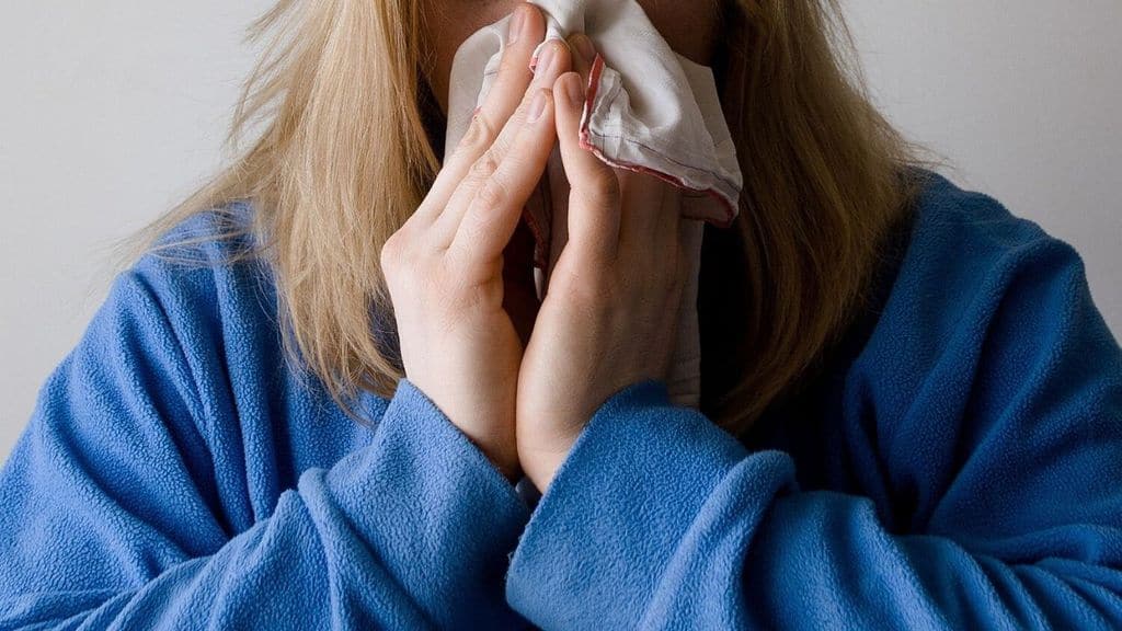 donna mentre si asciuga il naso con un fazzoletto