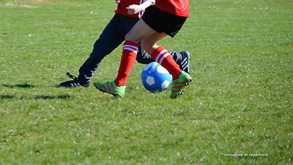 gambe di bambini che giocano a calcio