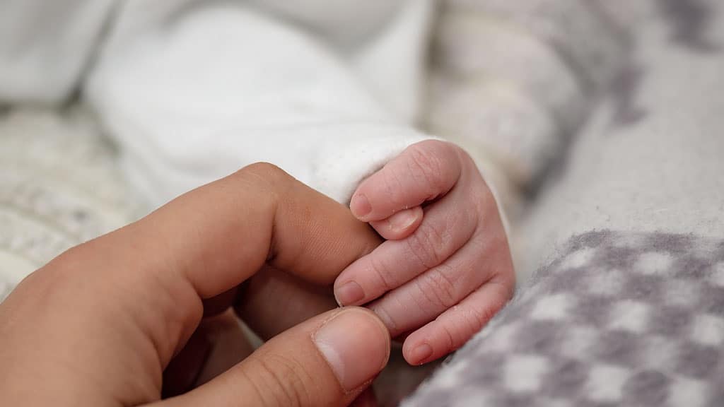 mano di uomo e neonato