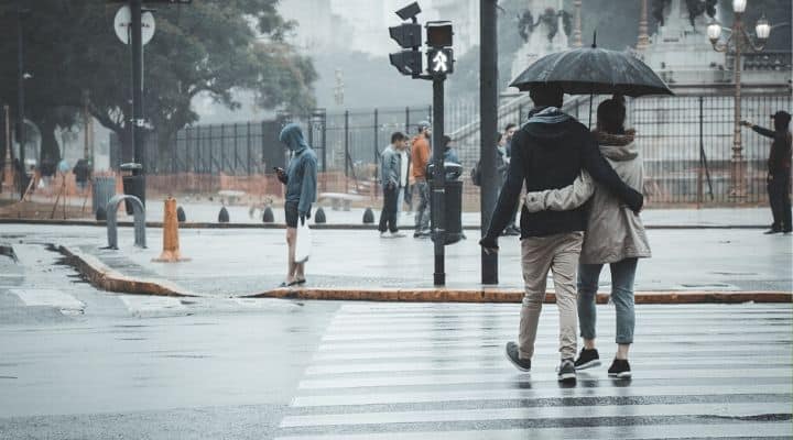 Persone sotto la pioggia con ombrello