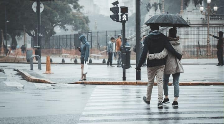 Persone sotto la pioggia con ombrello