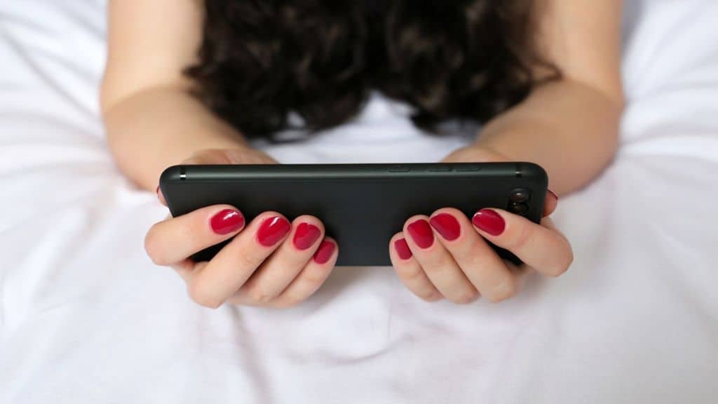 mani di donna che tengono un cellulare