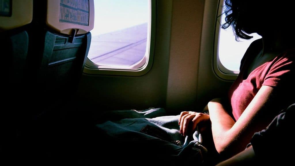 una ragazza in aereo vicino al finestrino