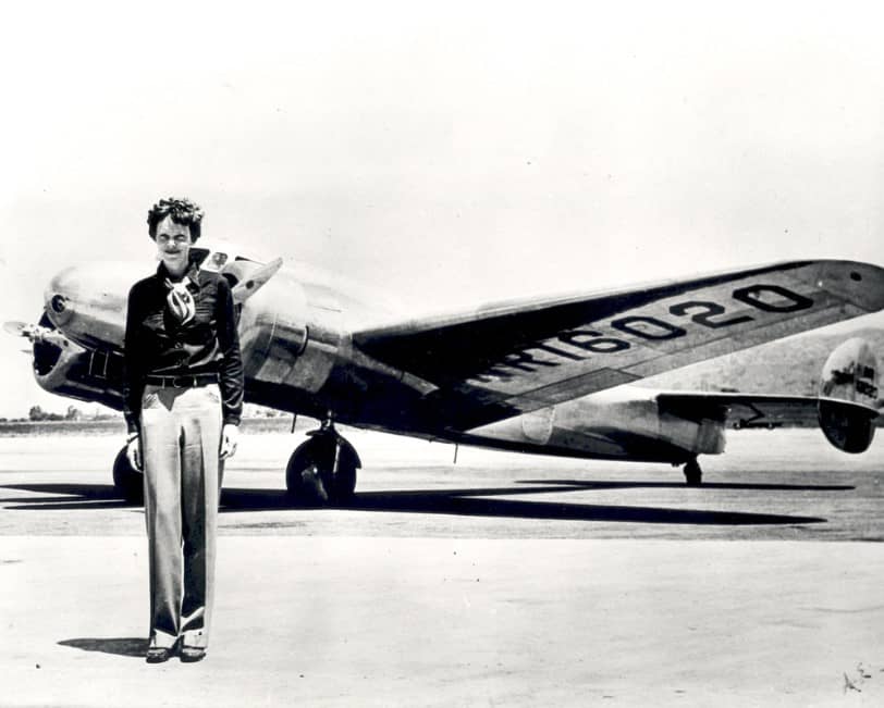 amelia earhart in piedi di fronte al suo aereo