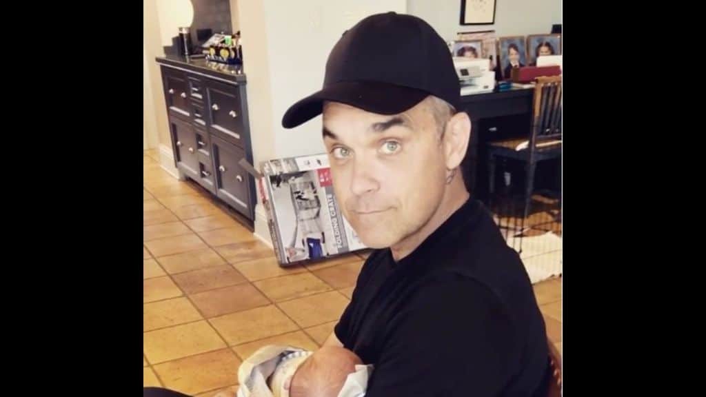 robbie williams mentre tiene in braccio il figlip