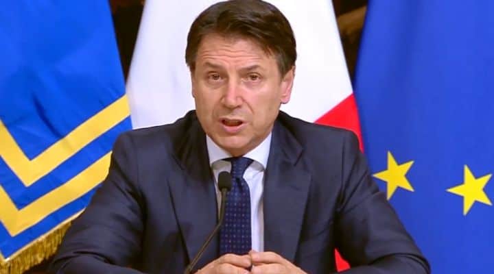 Giuseppe Conte, mezzo busto. Dietro di lui la bandiera italiana e quella dell'Unione Europea