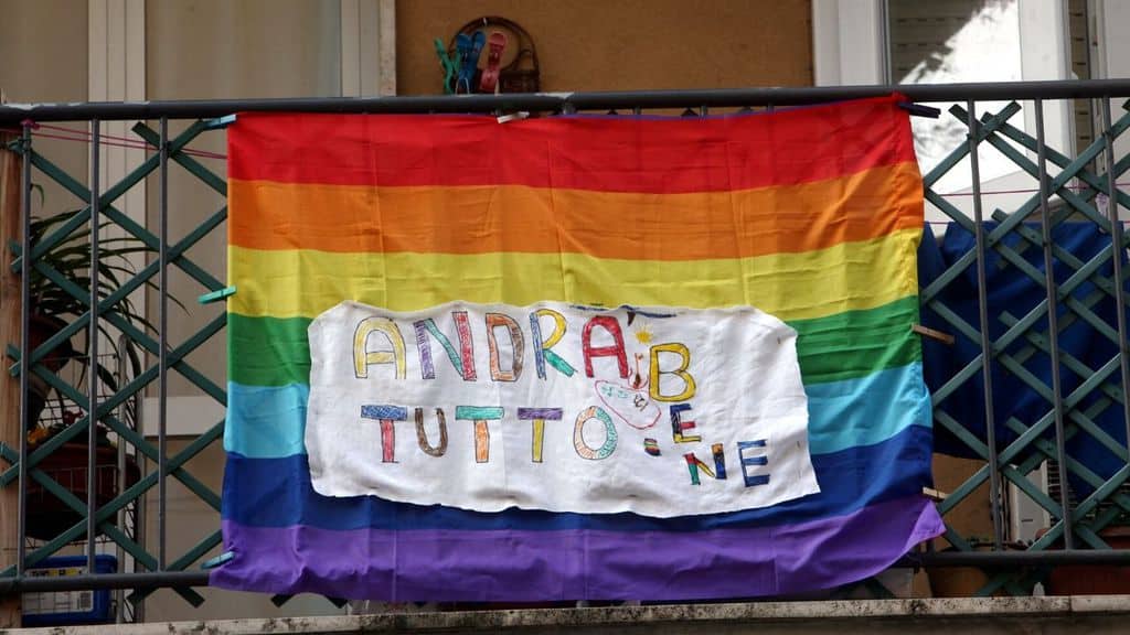 bandiera della pace dal balcone con scritto "andrà tutto bene"