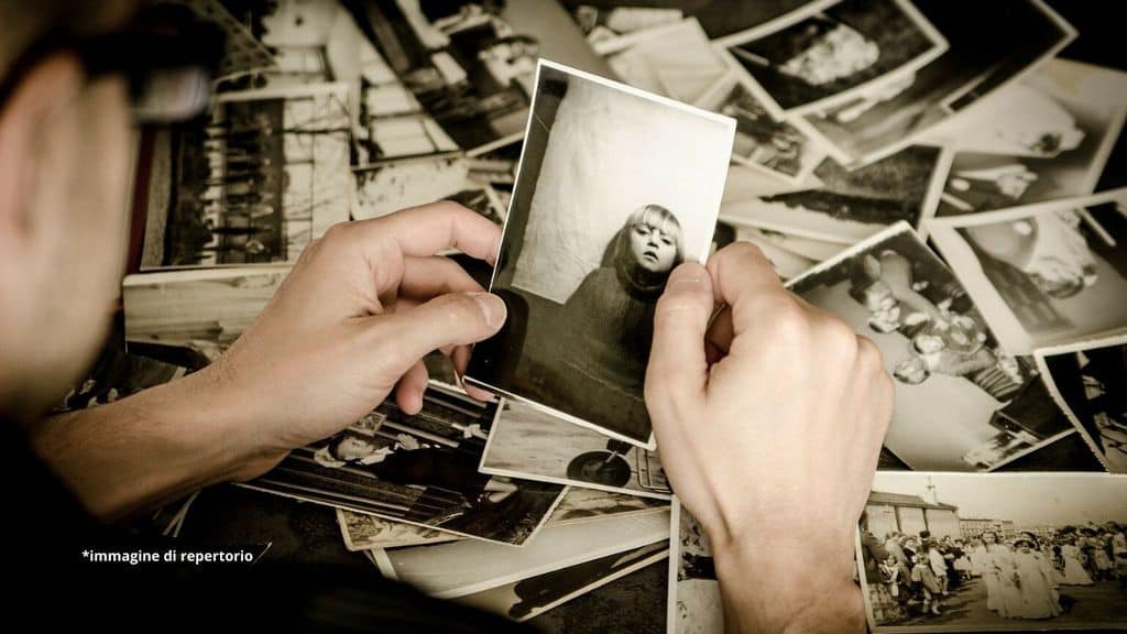 una mano che tiene una fotografia in bianco e nero