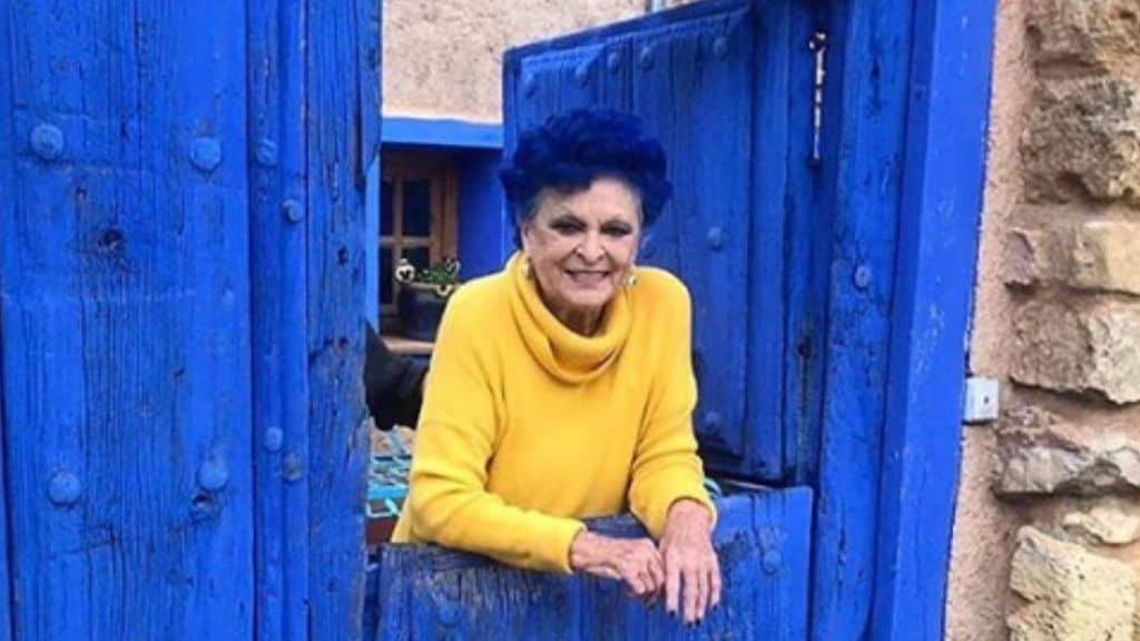 lucia bosé affacciata da una finestrella blu