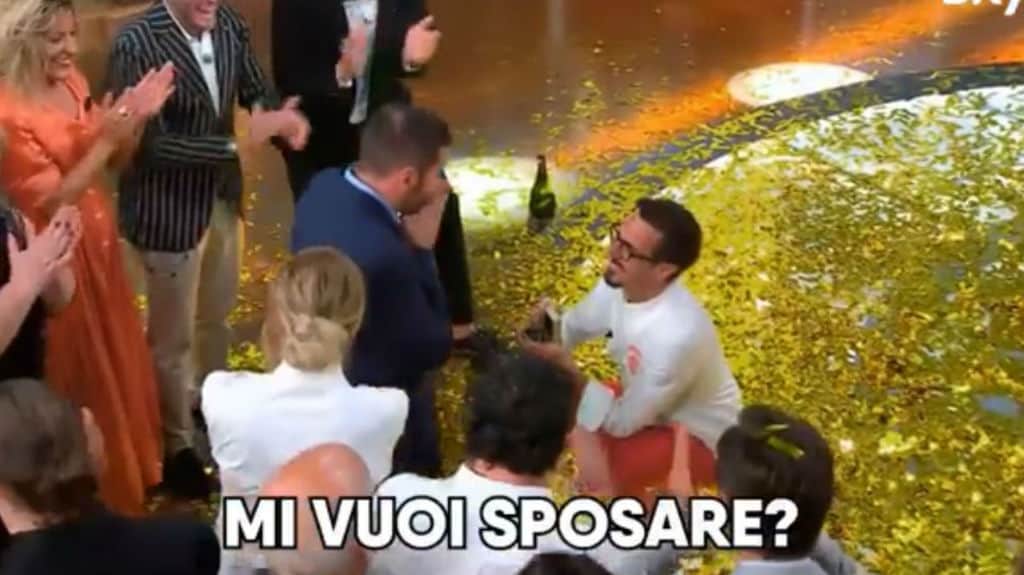 lo chef inginocchiato di fronte al compagno per chiedergli di sposarlo